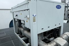 Chłodzony powietrzem chiller Carrier z czynnikiem R134a na dachu, widoczne sprężarki i parownik