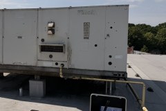 Pomiar sprawności rooftopa na dachu: walizka pomiarowa z laptopem i sondami przy urządzeniu York