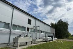 Podpis (Caption): Instalacja chłodnicza na zewnątrz hali przemysłowej w ramach realizacji projektu SKiC.