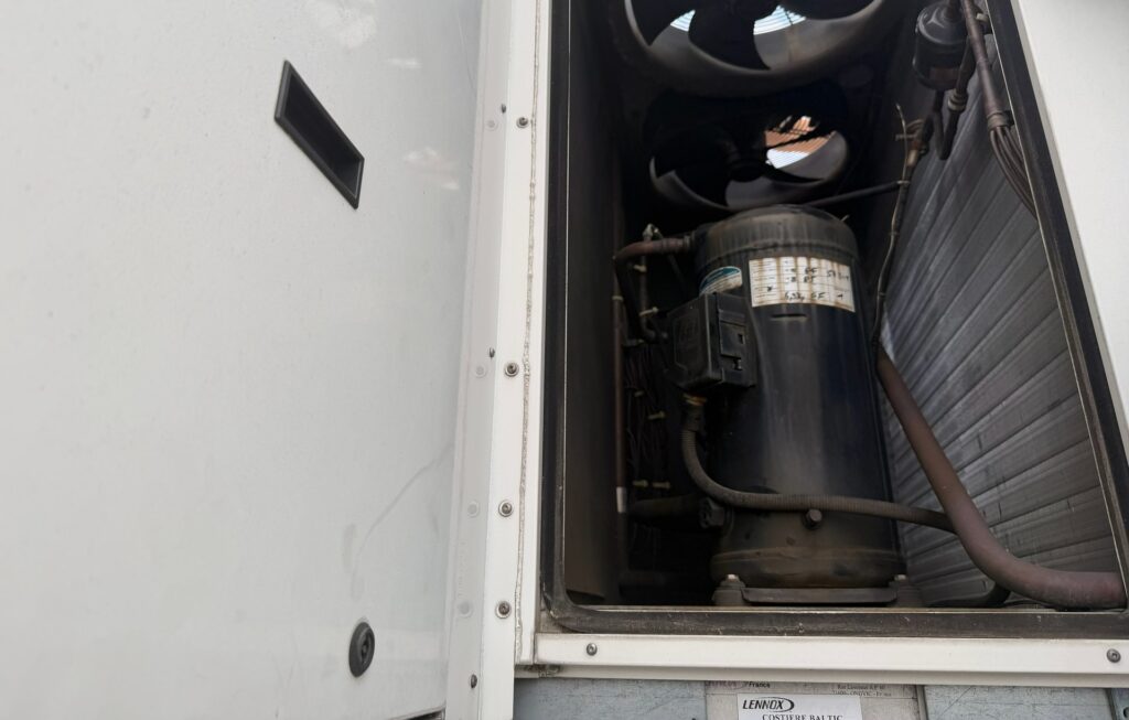 Otwarta komora rooftopa Lennox: wentylatory osiowe, sprężarka i wężownica wymiennika