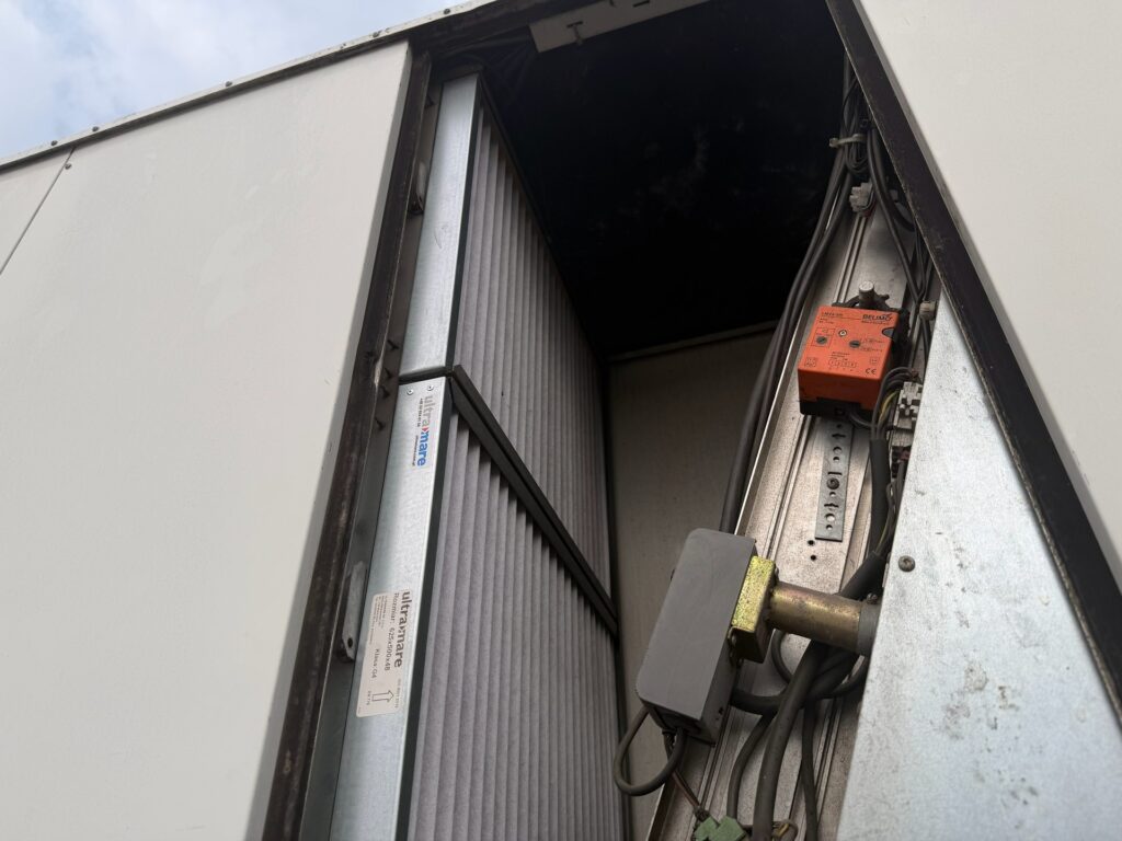 Filtry powietrza i siłownik przepustnicy w komorze mieszania rooftopa Lennox